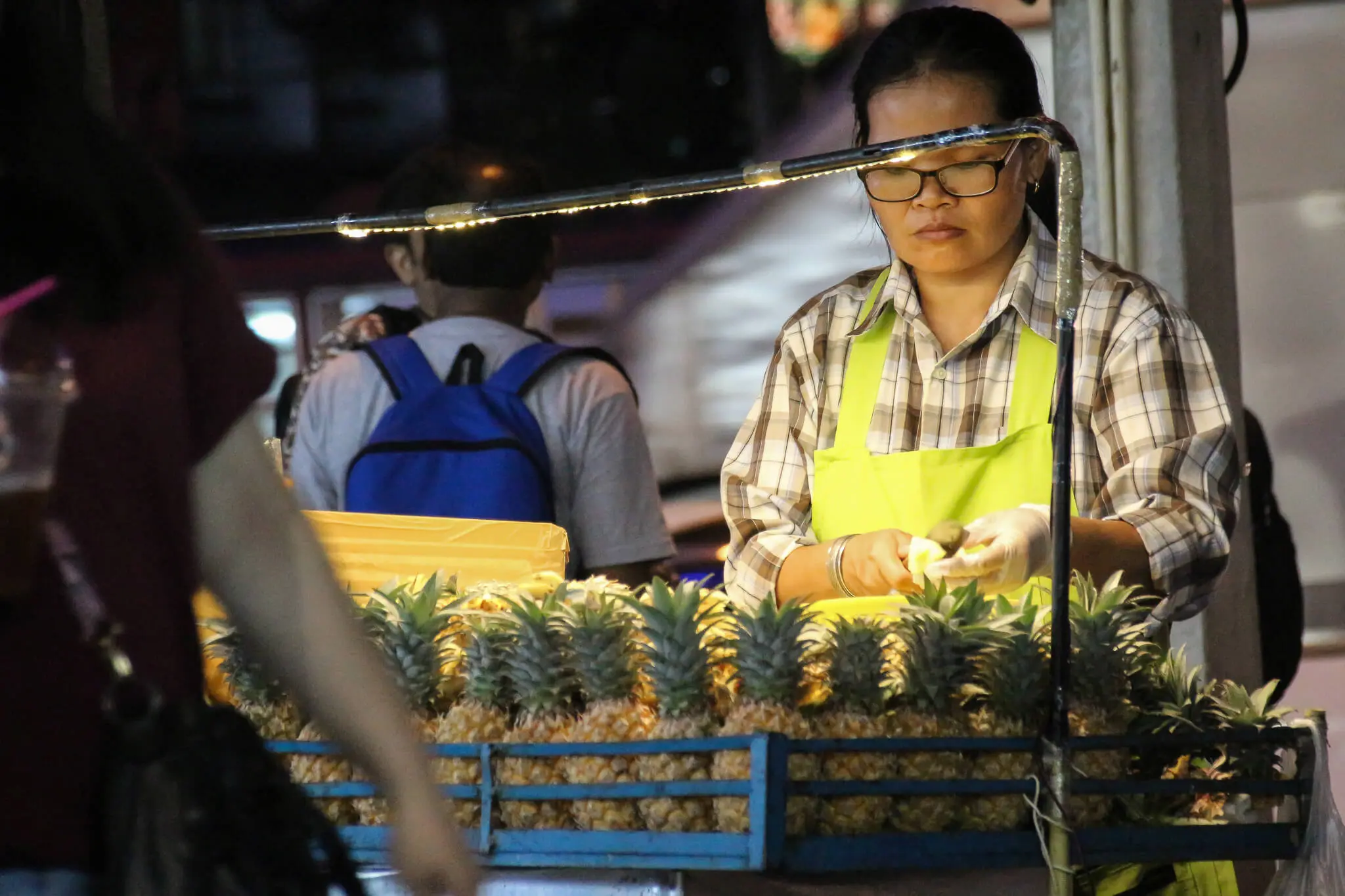 Eine Straßenverkäuferin mit Ananas