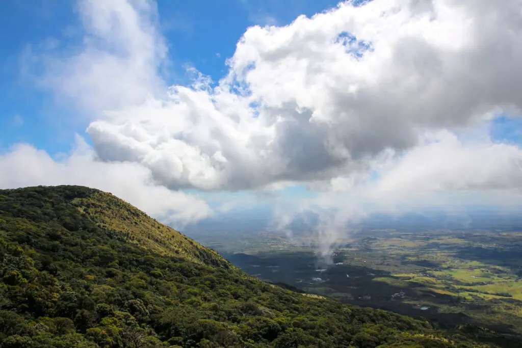 Gebirgslandschaft mit blauen Wolken über sonnigen Hügeln