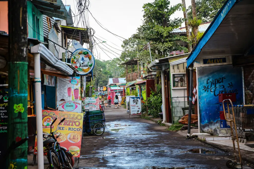 Bunte Häuserwand mit Graffiti und regennasser Straße