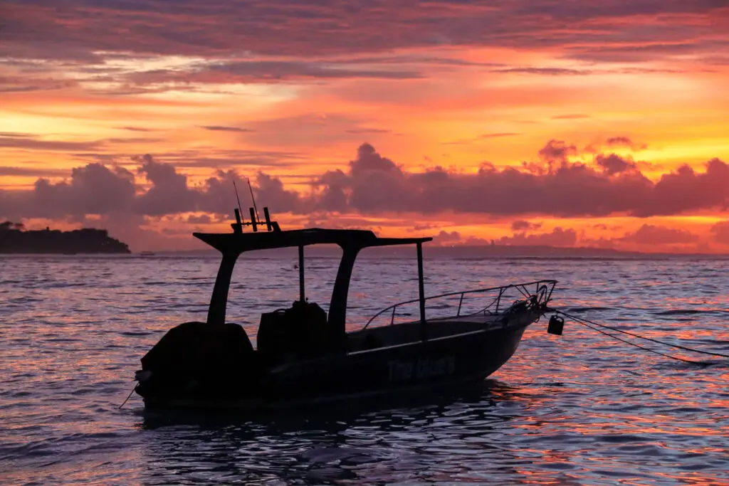 Schattiertes Boot bei Sonnenuntergang am Meer