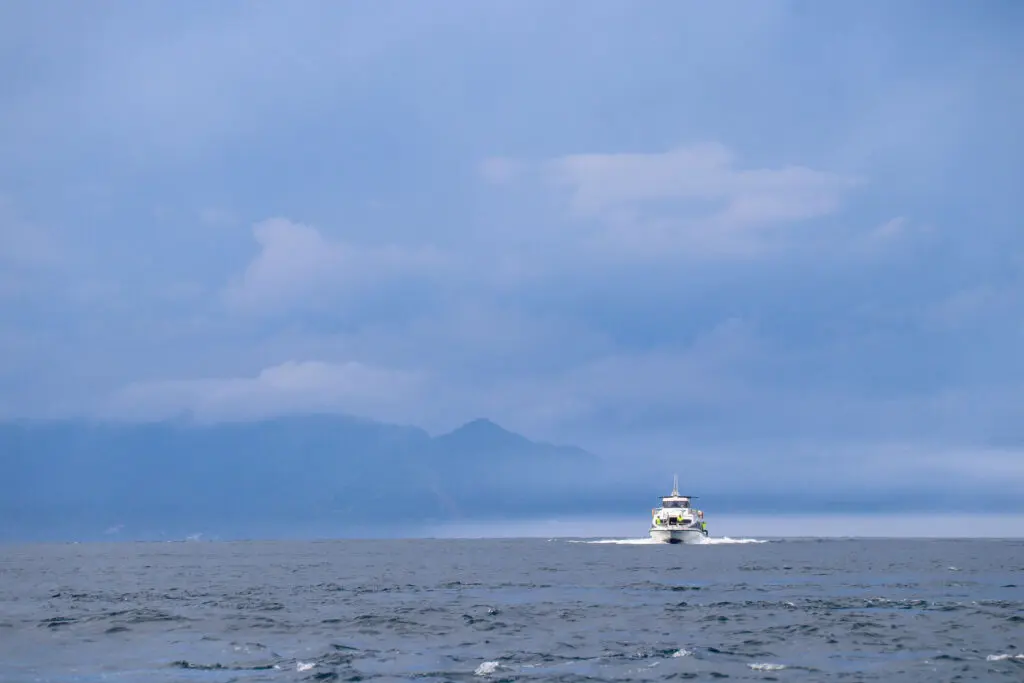Boot auf offenem Meer vor Vulkaninsel