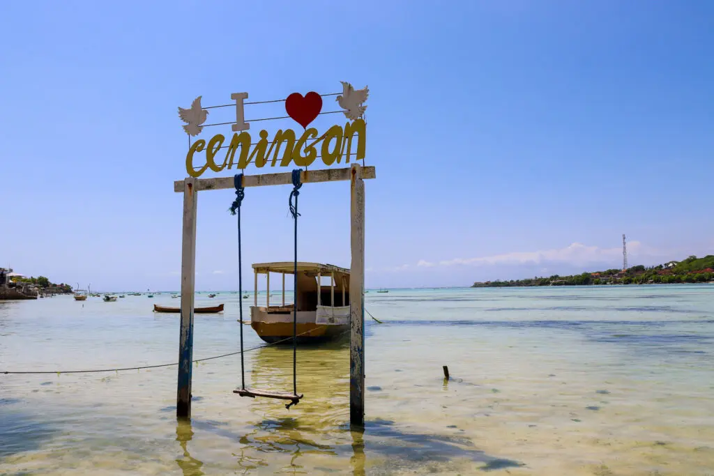 Schaukel mit Ceningan-Schriftzug im Meer