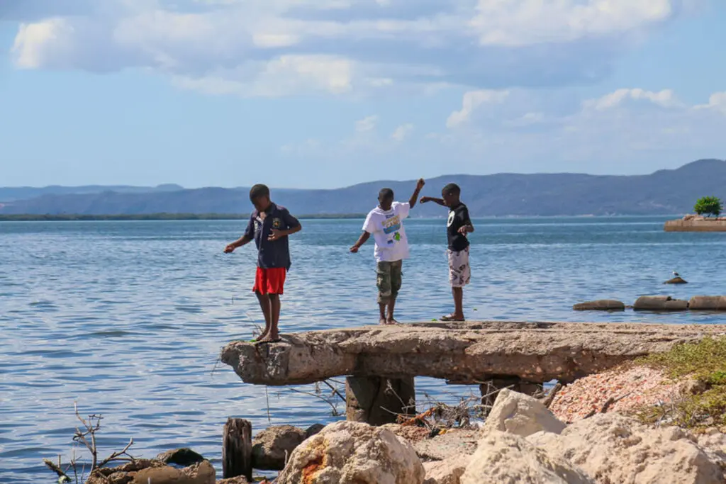 Drei Kinder auf Felsen vor der Küste