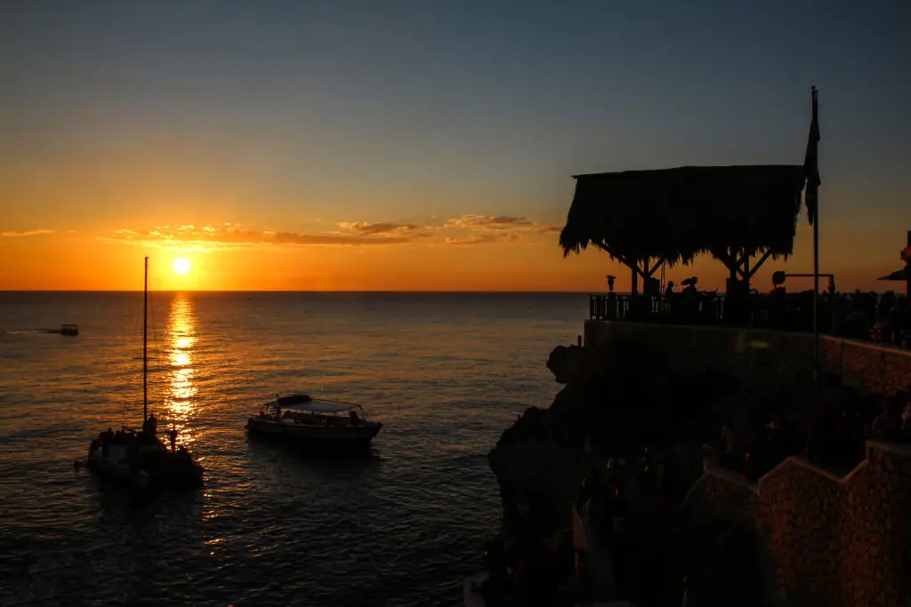 Abendstimmung an der Klippe mit Boot und Sonne