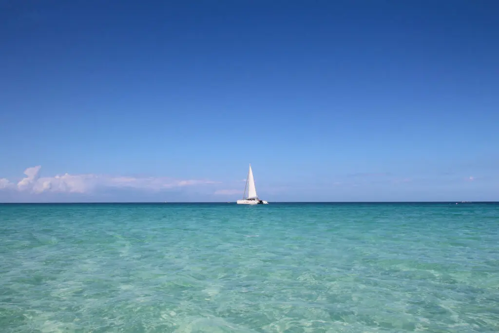 Weißes Segelboot gleitet übers türkisblaue Wasser