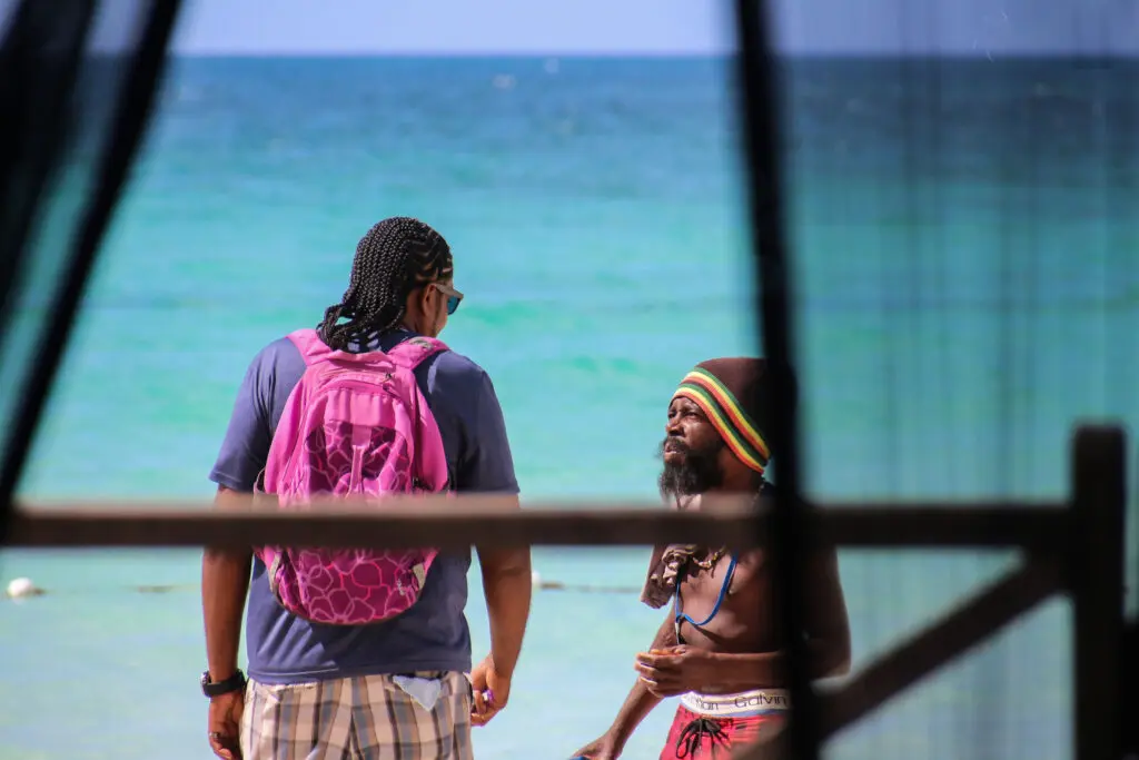 Zwei Jamaikaner durch den Vorhang fotografiert mit Blick auf das Meer