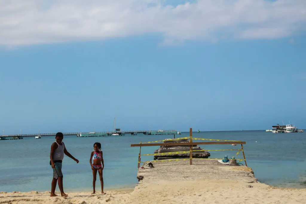 Zwei Kinder auf Holzsteg am Strand von Montego Bay