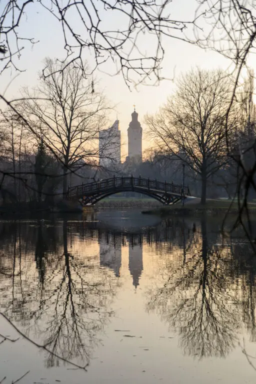 Spiegelung der Leipziger Skyline im Wasser bei Sonnenuntergang