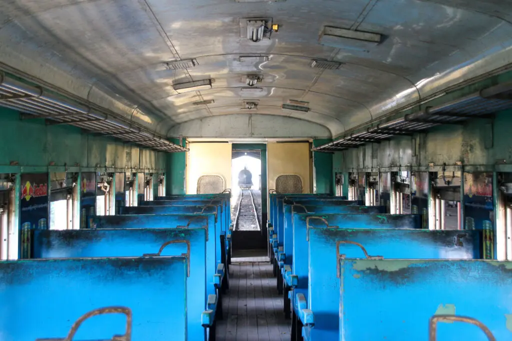 Innenansicht eines alten Zugwaggons mit blauen Sitzen