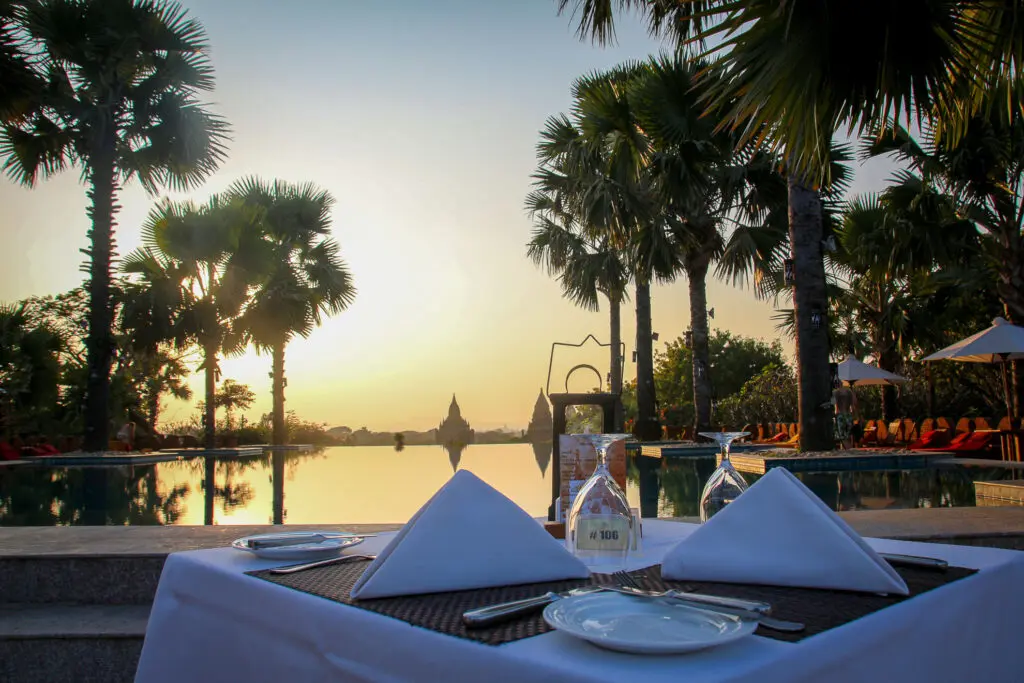 Abendessen am Pool mit Palmen und goldener Sonne