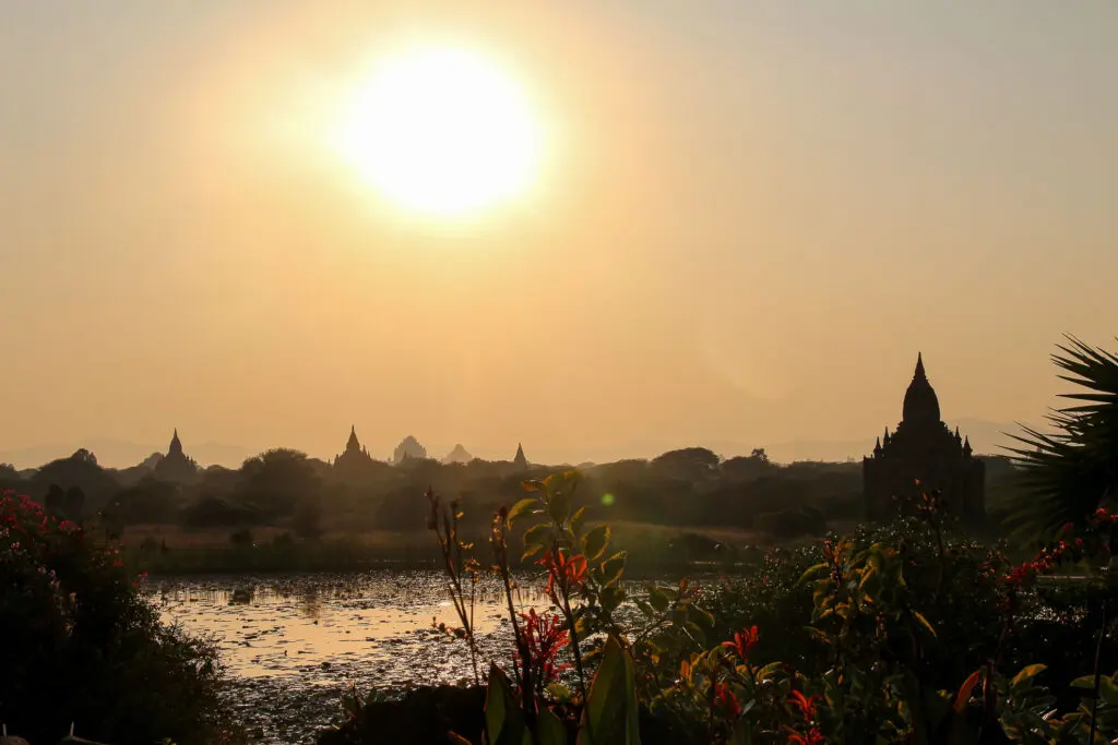 Sonnenreflexion im Wasser mit Pagode im Hintergrund