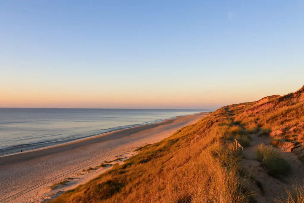 Rote Klippen und Sandstrand bei Abendlicht