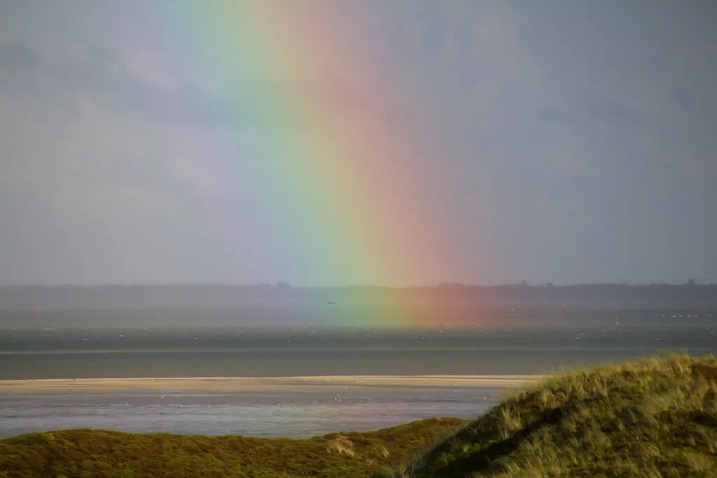 Regenbogen über dem Watt bei Ebbe