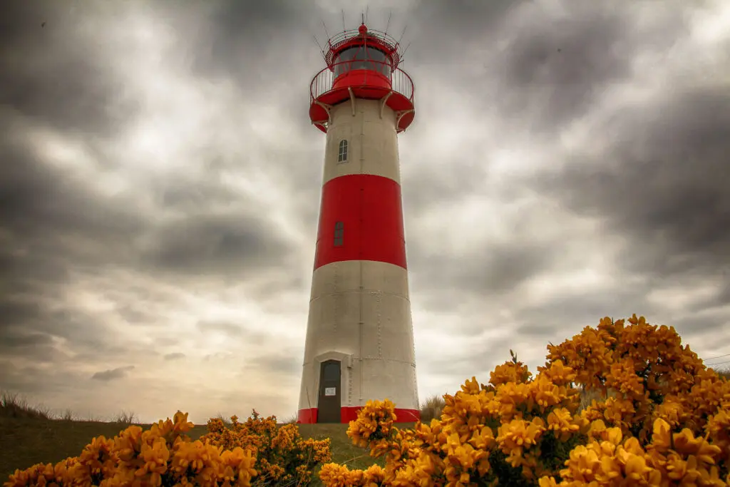 Rot-weißer Leuchtturm unter aufziehenden Wolken in List