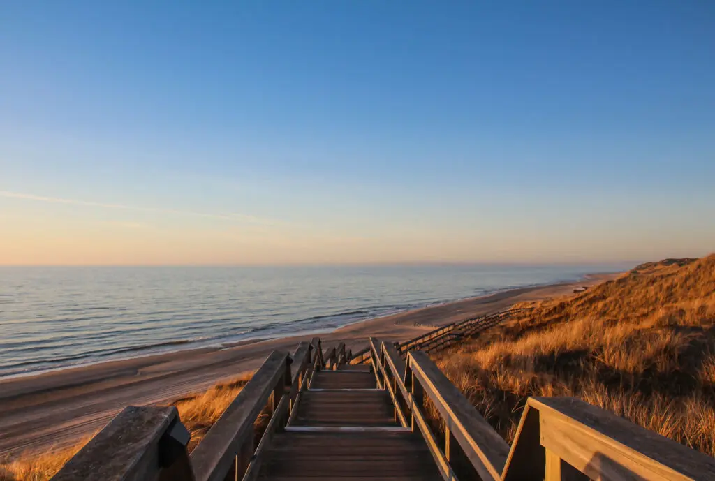 Sylt Galerie - Warme Farben auf Holzbohlenweg mit Meerblick im Sonnenuntergang