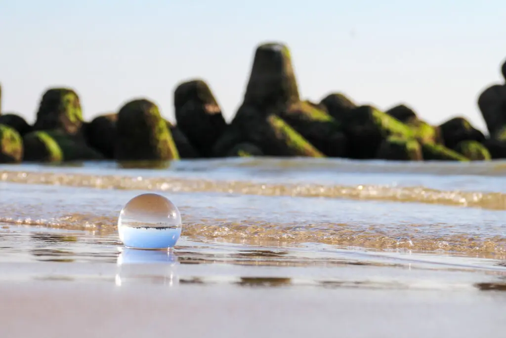 Nahaufnahme einer Glaskugel mit spiegelnder Wasseroberfläche