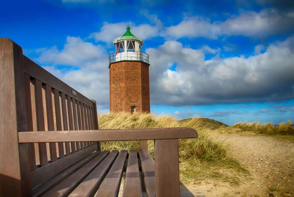 Quermarkenfeuer Leuchtturm und Holzbank im Dünengebiet
