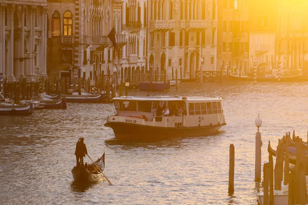 Boote und Gondeln in der Dämmerung mit goldener Sonne