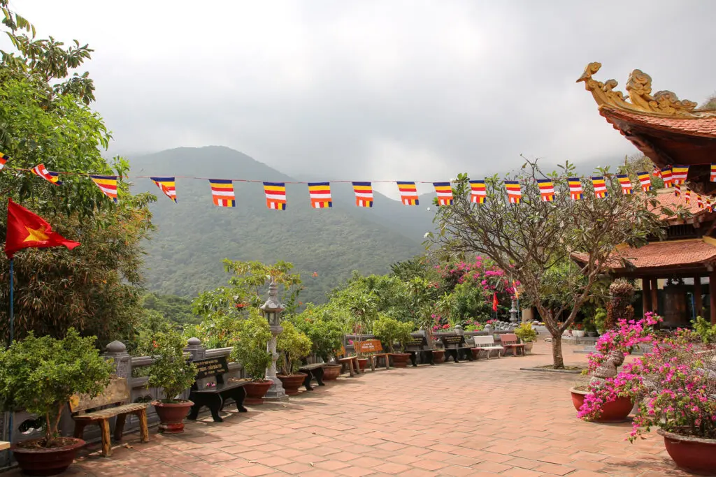 Platz mit buddhistischen Flaggen und Bergen im Hintergrund