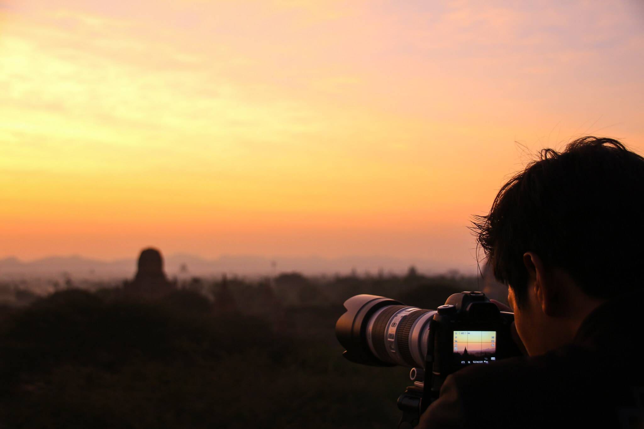 Mann mit Kamera der den Sonnenaufgang in Bagan Myanmar fotografiert
