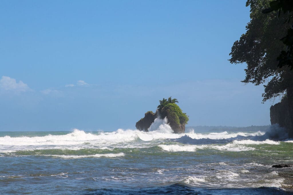 Brechende Wellen treffen auf Küstenfelsen bei Puerto Viejo