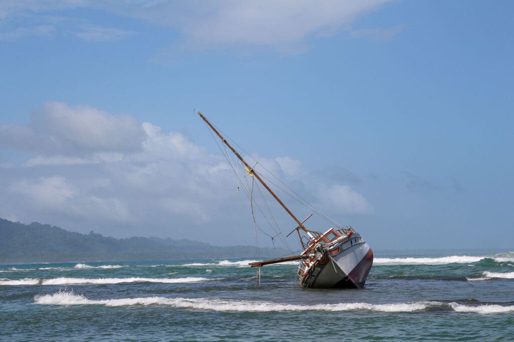 Altes Holzboot liegt schräg im Wasser vor der Küste von Costa Rica