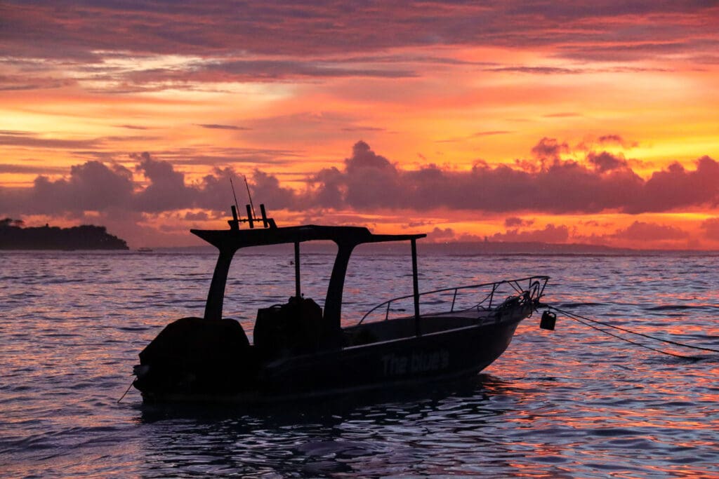 Schattiertes Boot bei Sonnenuntergang am Meer