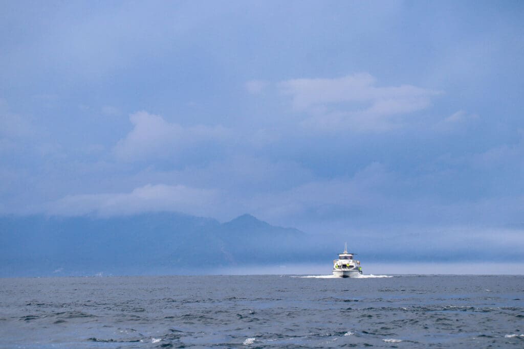 Boot auf offenem Meer vor Vulkaninsel