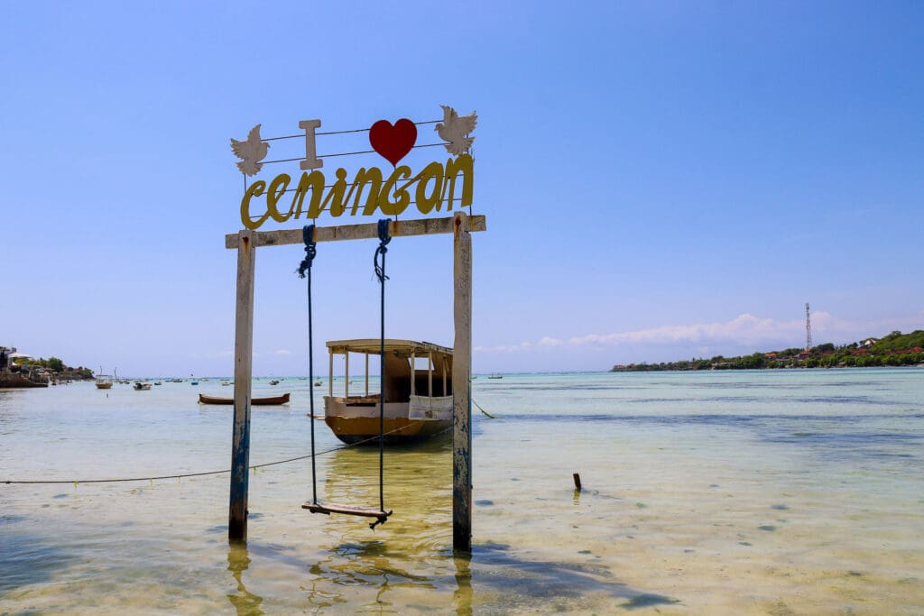 Schaukel mit Ceningan-Schriftzug im Meer