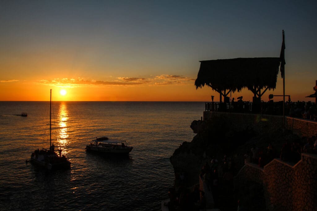 Abendstimmung an der Klippe mit Boot und Sonne