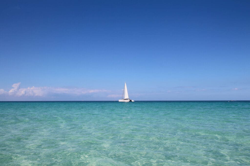 Weißes Segelboot gleitet übers türkisblaue Wasser