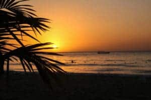 Sonnenuntergang über dem Meer mit kleinem Fischerboot