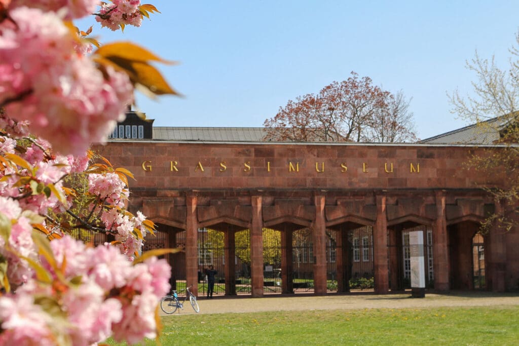 Blühende Zweige rahmen klassisches Gebäude ein
