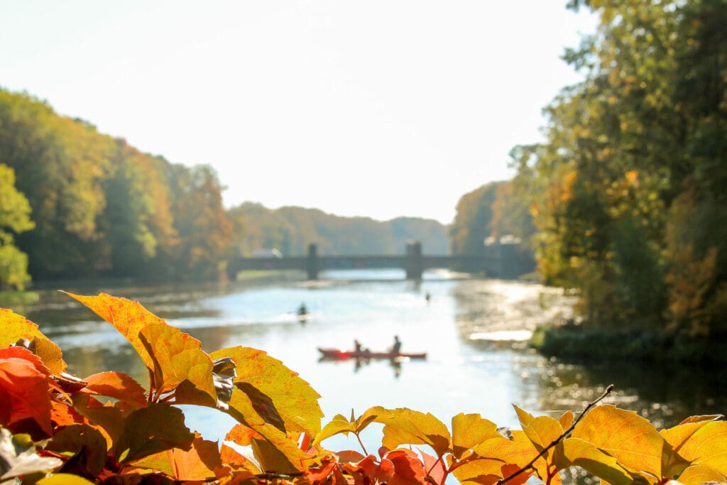 Kanufahrer im herbstlichen Flusslauf Leipzigs