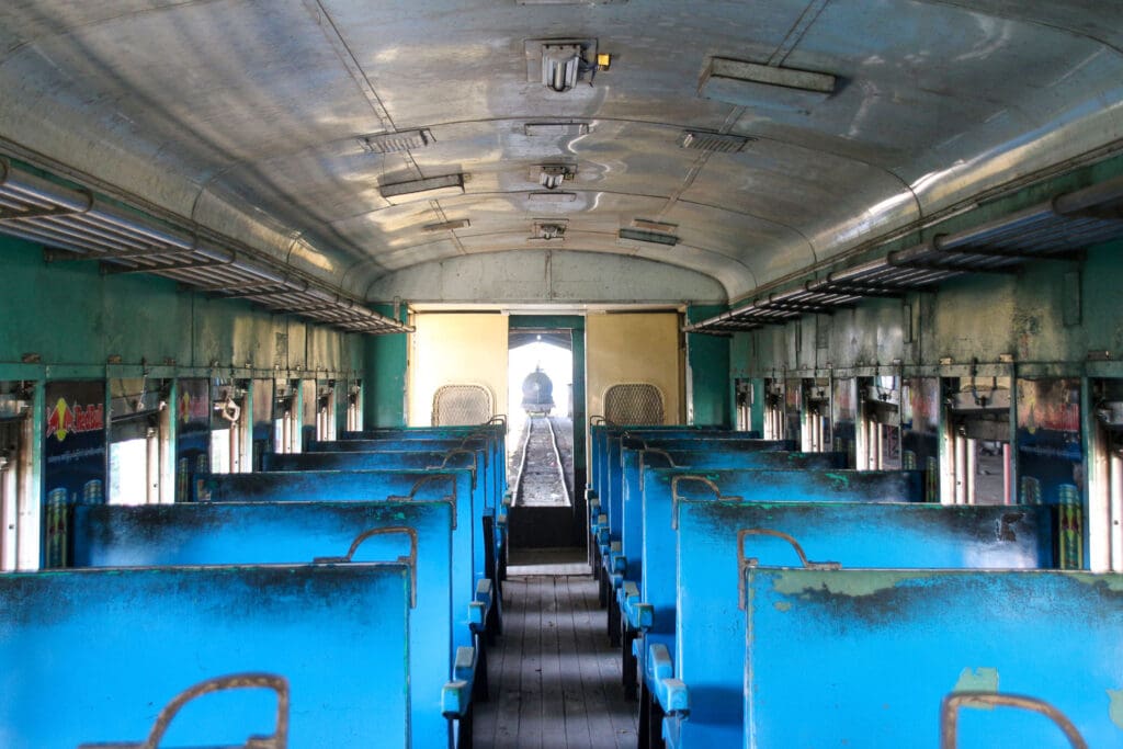 Innenansicht eines alten Zugwaggons mit blauen Sitzen