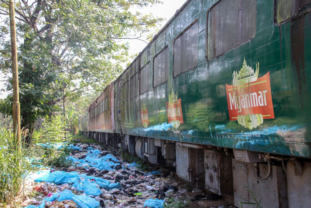 Bunter, verlassener Zug neben Müllhaufen