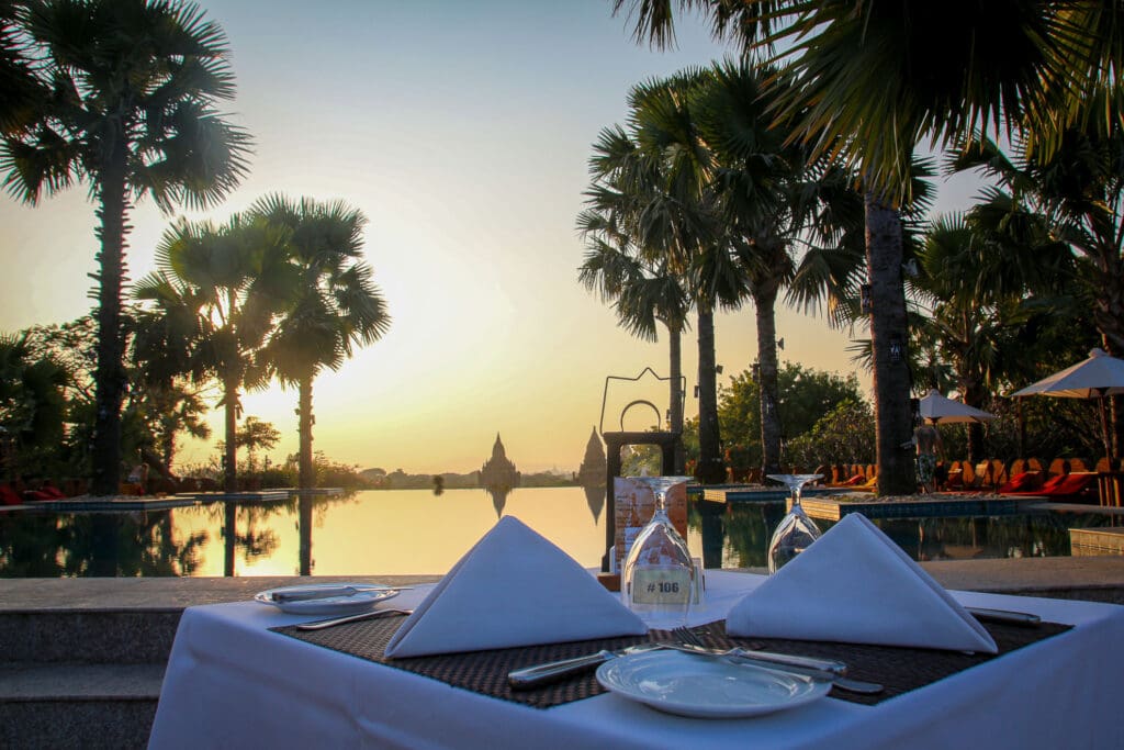 Abendessen am Pool mit Palmen und goldener Sonne