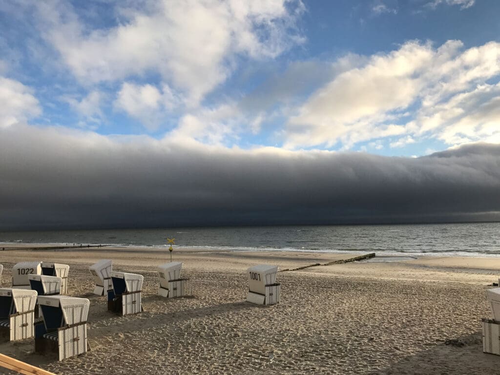 Bedrohlich dunkle Wolken über leerem Strand mit Strandkörben