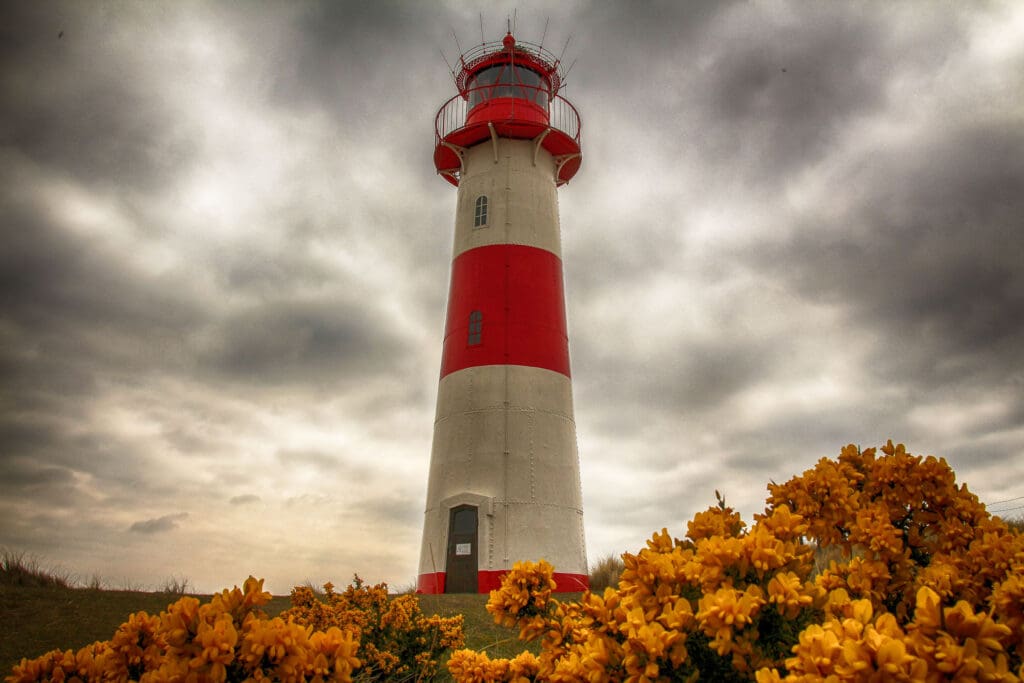 Rot-weißer Leuchtturm unter aufziehenden Wolken in List