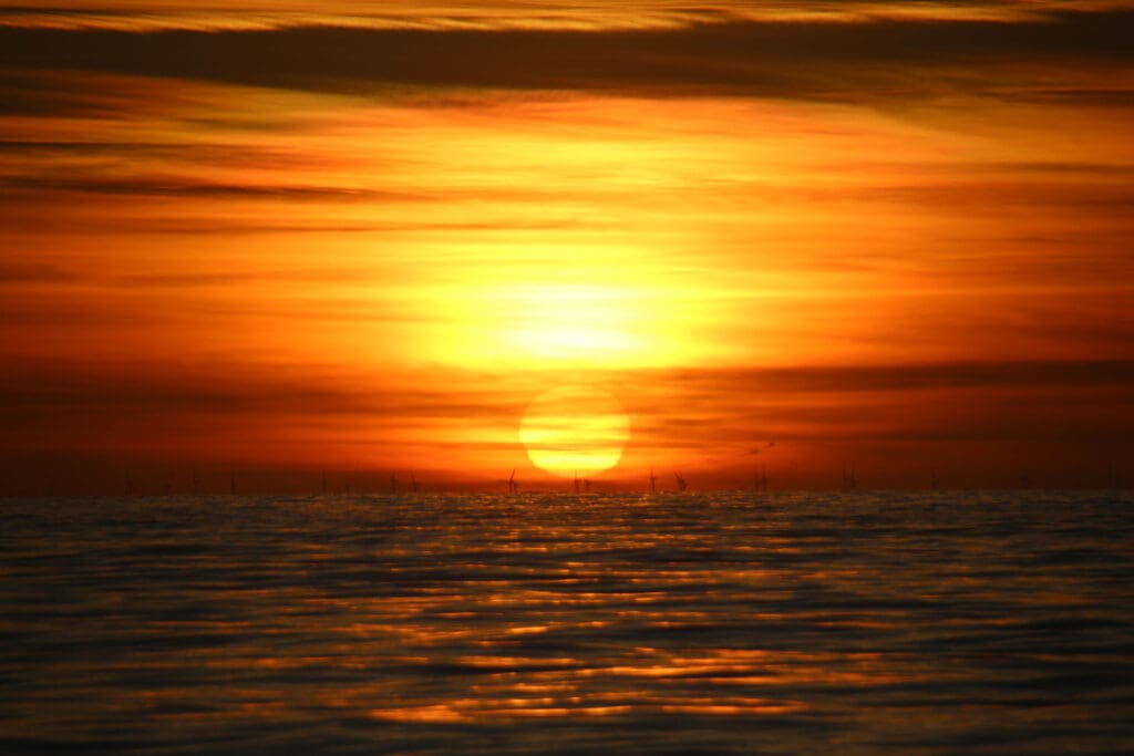 Leuchtende Sonne berührt den Horizont über der Nordsee