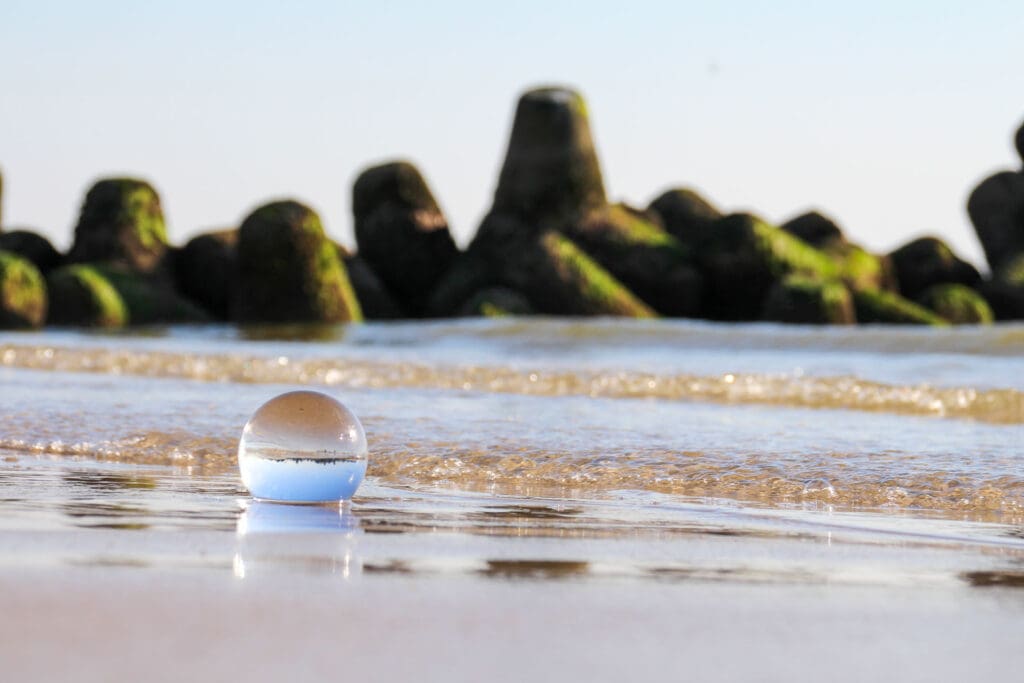 Nahaufnahme einer Glaskugel mit spiegelnder Wasseroberfläche