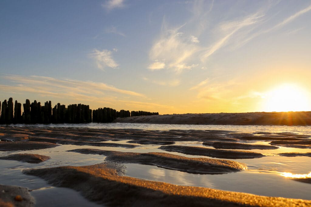 Blick auf das Wattenmeer bei Ebbe mit markanten Rillen und Abendhimmel
