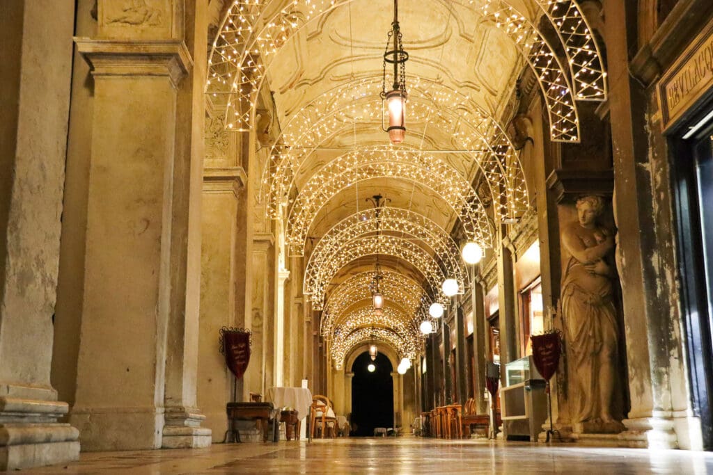 Abendlich beleuchteter Säulengang auf dem Markusplatz