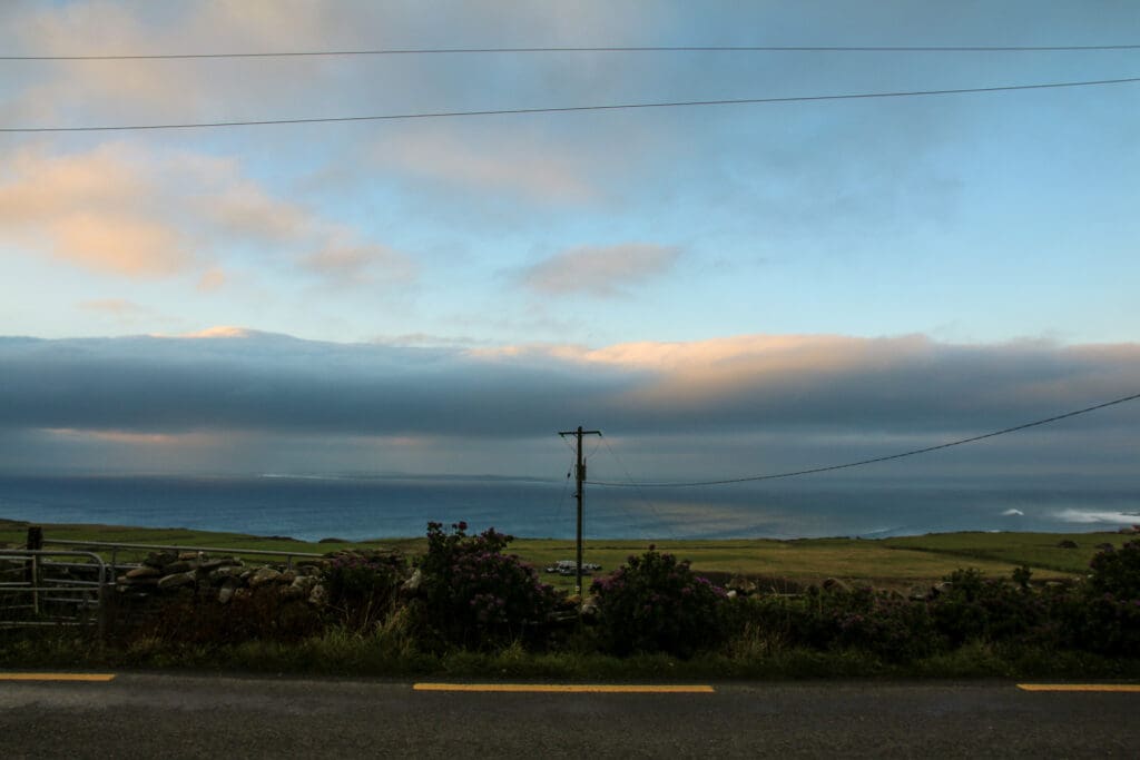 Offene Felder mit Stromleitung und weitem Himmel, Irland