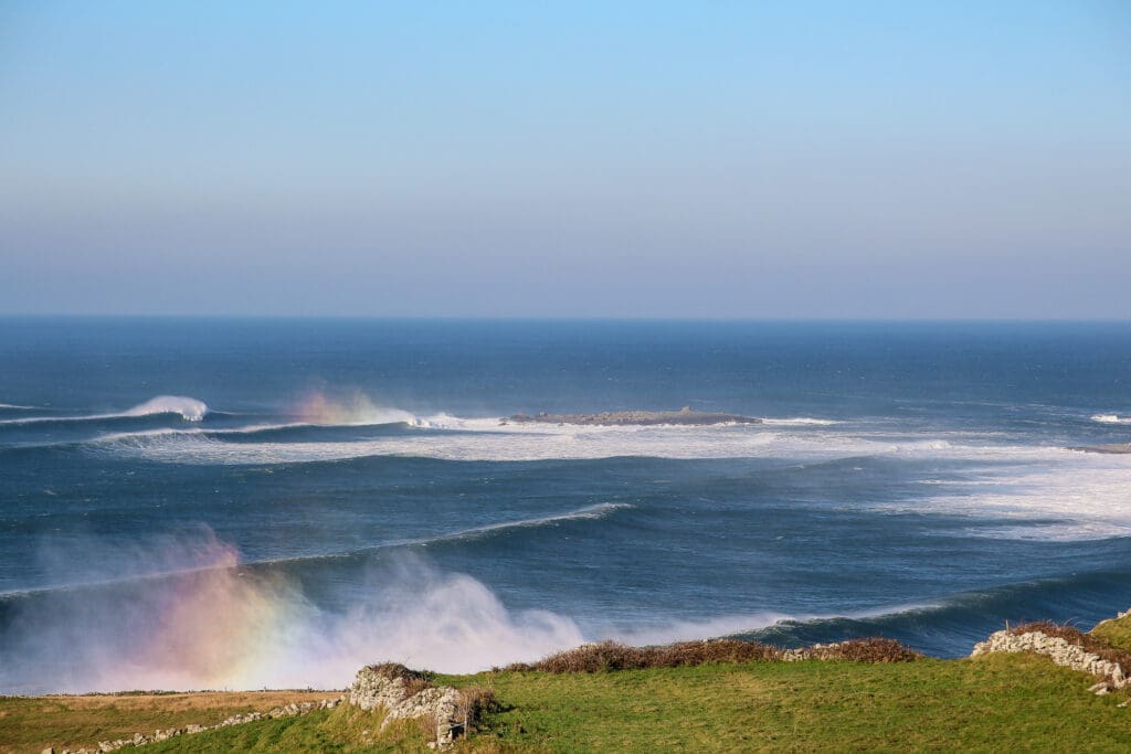 Wellen mit Regenbogen in der Gischt