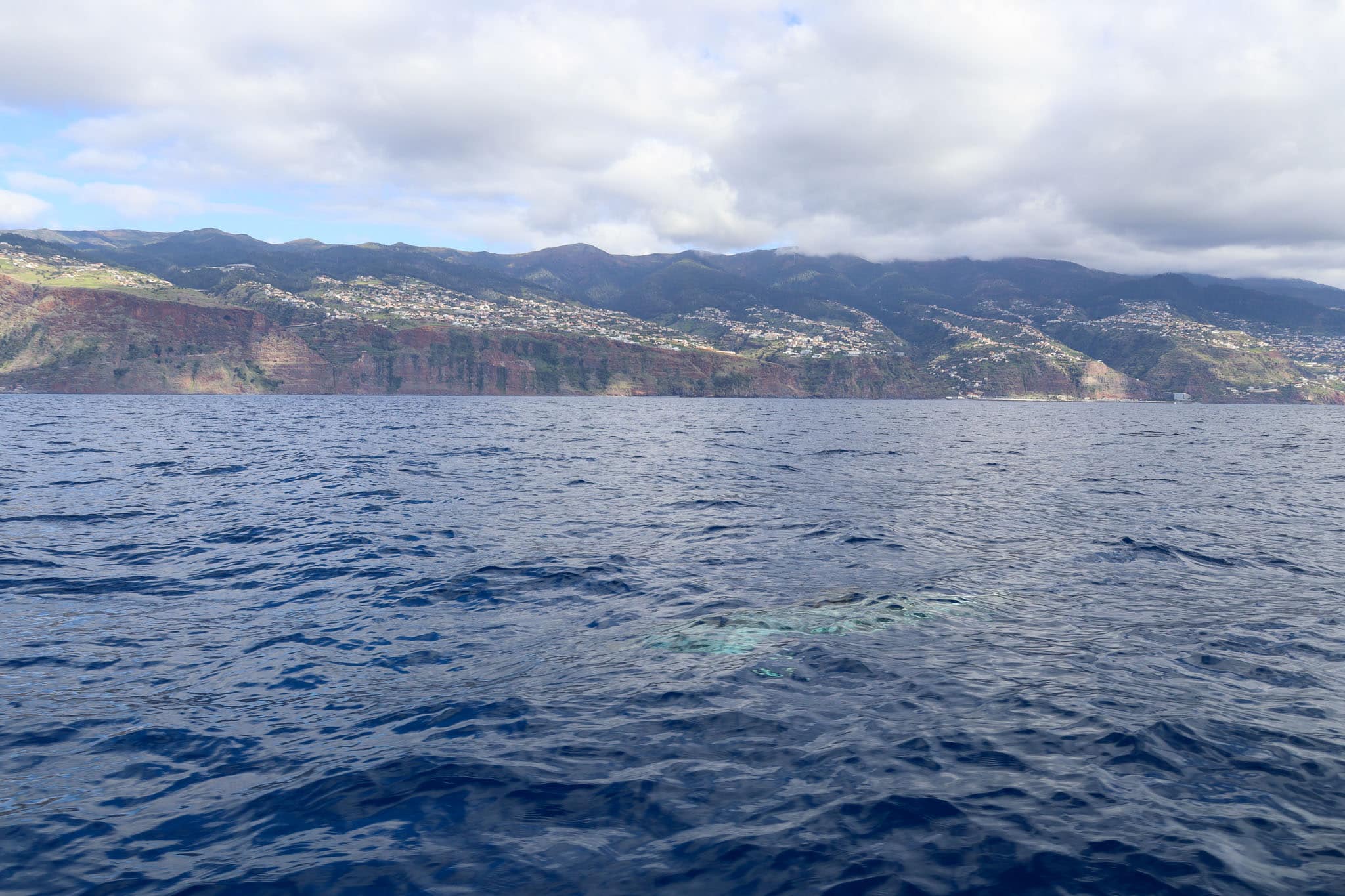 Blick aufs offene Meer bei leicht bewölktem Himmel