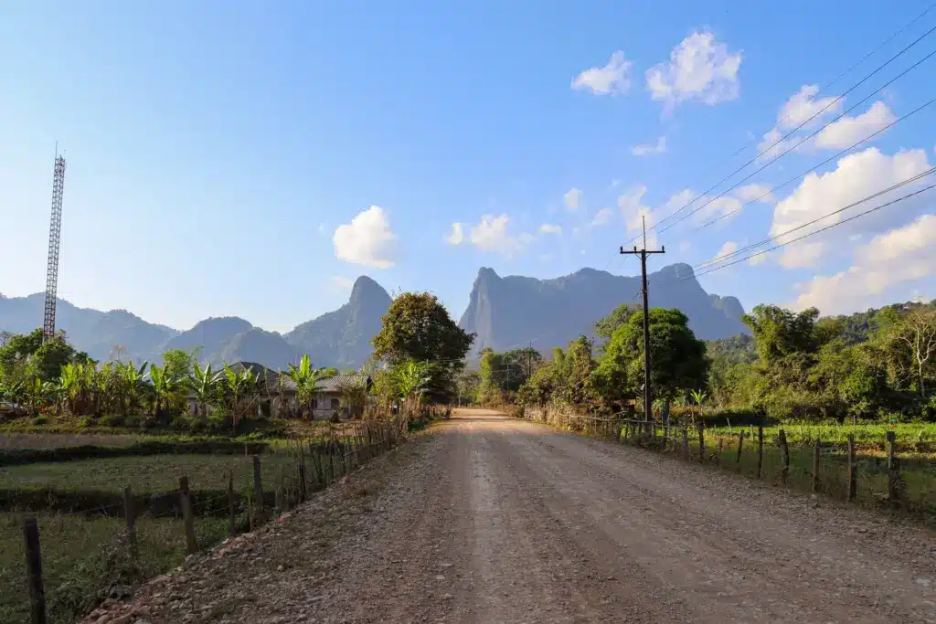 Strasse Palmen Karstberge Vang Vieng Laos blauer Himmel