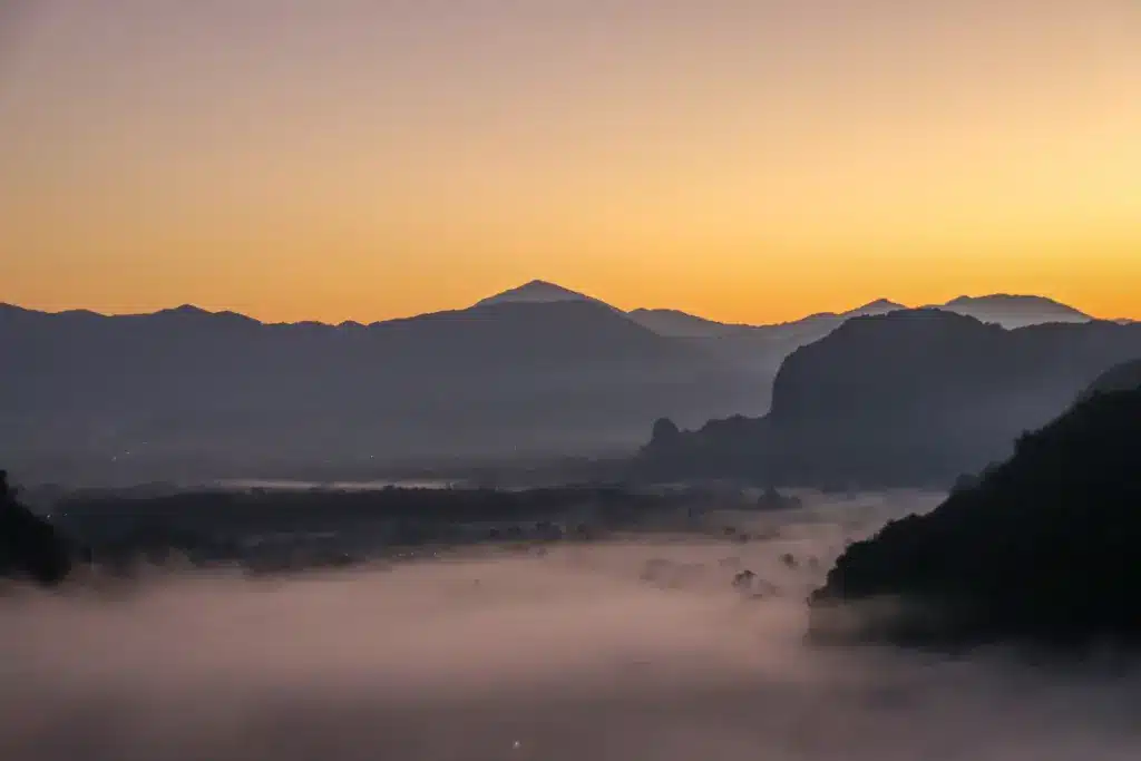 Karstberge Sonnenaufgang Nebel Vang Vieng Landschaft orange