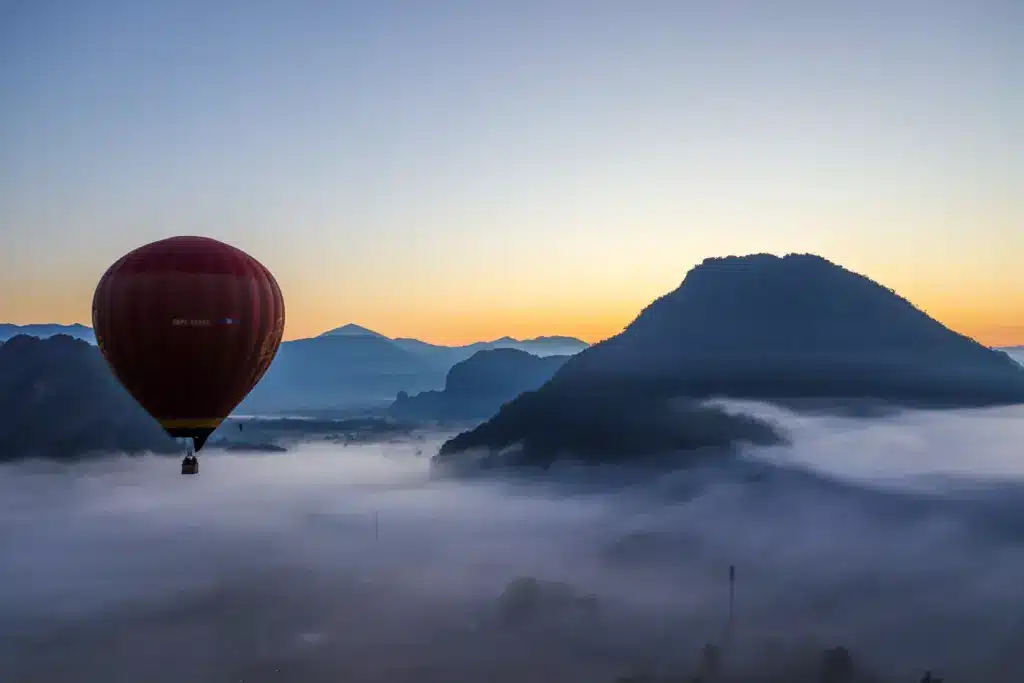 Heissluftballon Karstberge Nebel Sonnenaufgang Vang Vieng dunkel