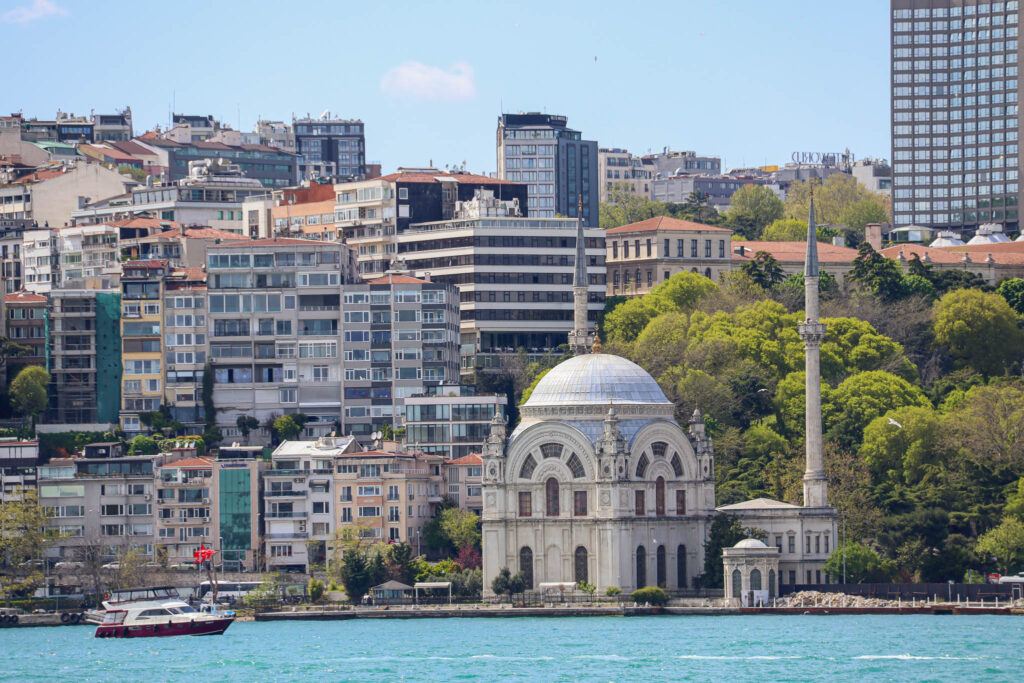 A domed historic building stands alongside modern architecture and a marina on the Istanbul waterfront, Bosphorus, Turkey